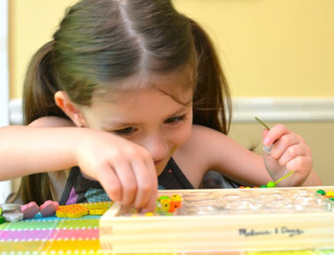 Girl playing with Melissa & Doug wooden box