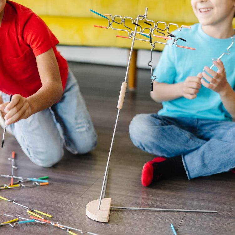 A kid playing with the Melissa & Doug Suspend Family Game (31 pcs)