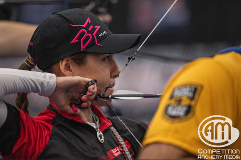 Toja Ellison is at full draw with her arrows fletched with TAC Drivers.