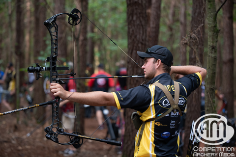 Remington Boyer taking aim with his arrows fletched on white TAC Wraps.