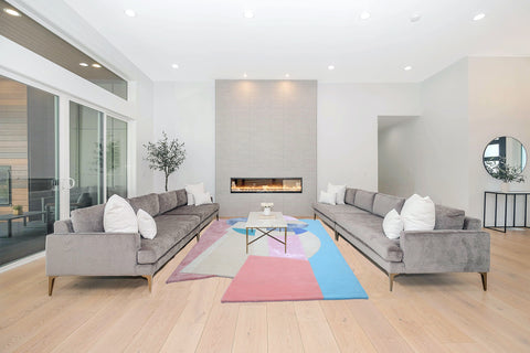 Fun rug in pink and blue color wool and silk odd-shaped irregular rug by ruggism in gray living room with white walls