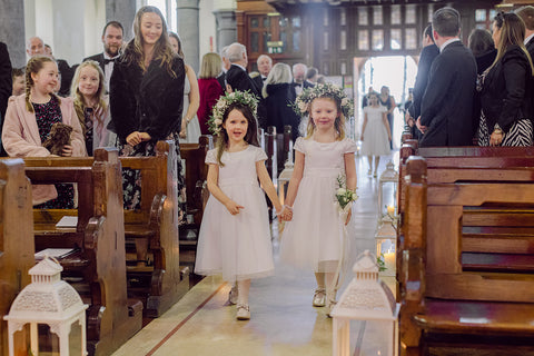 Flower girls walking on the church isle with big smiling faces