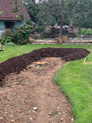 Fresh compost going onto a new flower border.