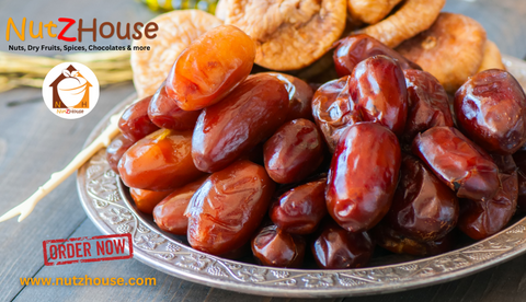 A cluster of ripe, golden dates on a white plate.