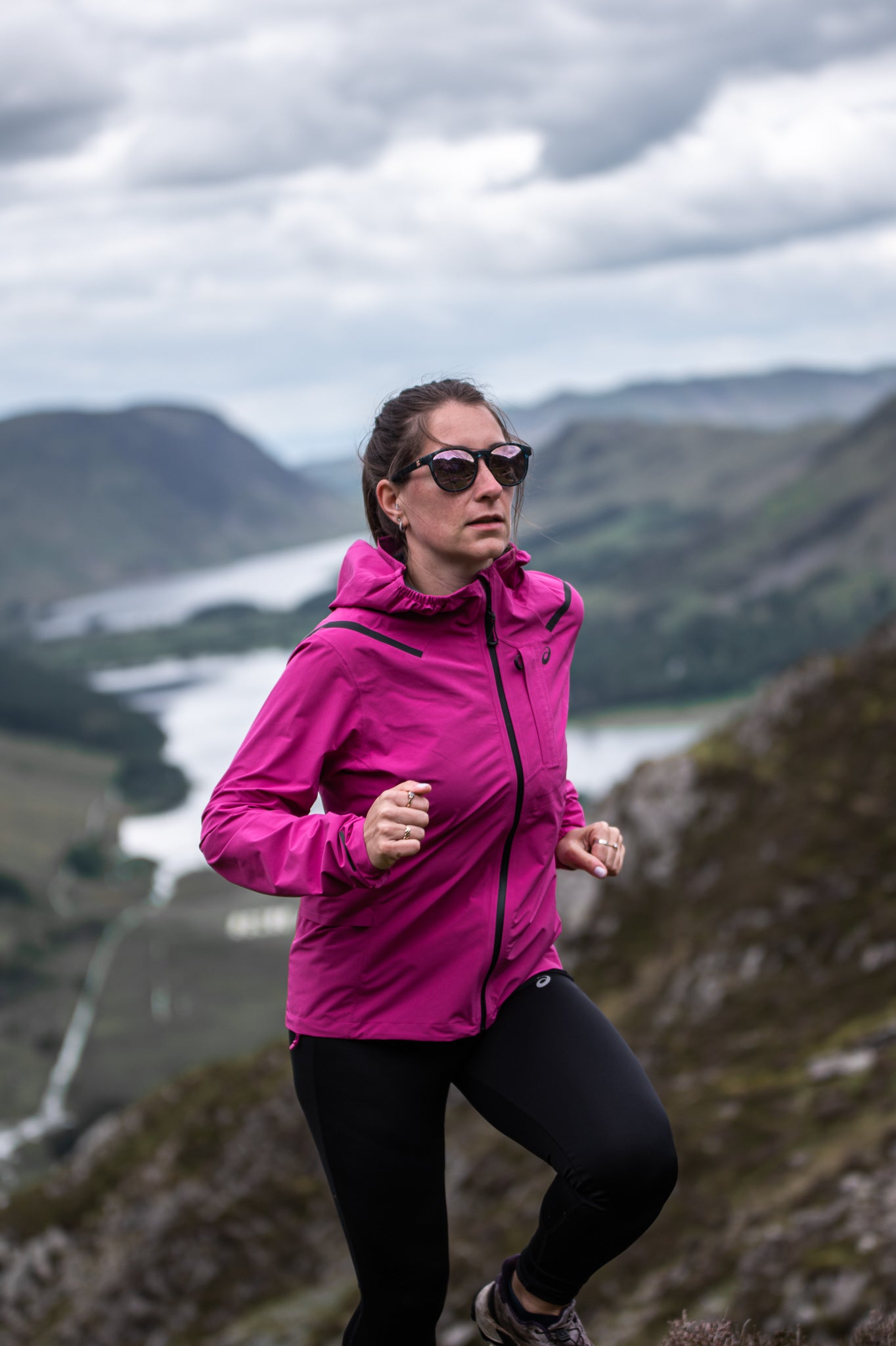 celina hanson trail runner styrkr athlete running up hill in a pink jacket