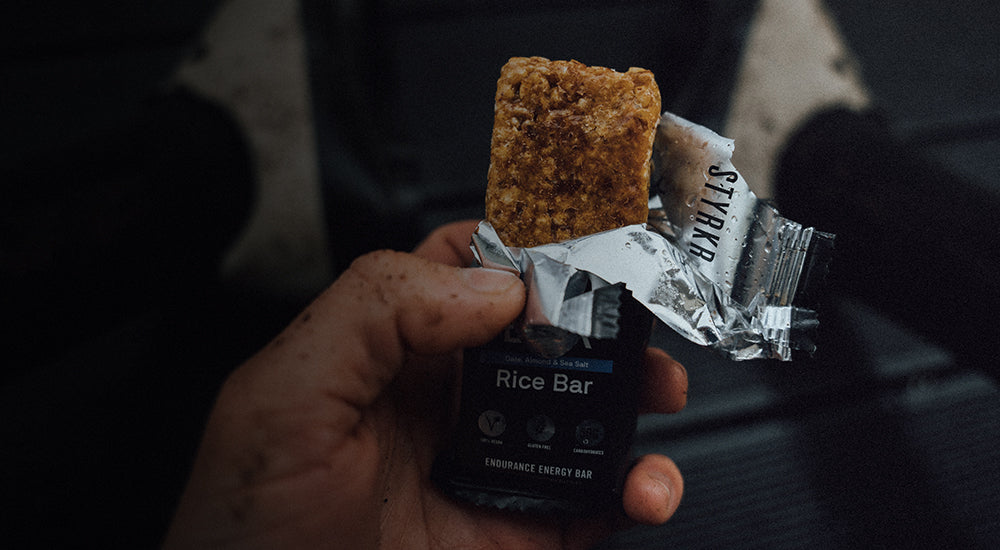 Atleta sosteniendo una barra de arroz energética Styrkr abierta