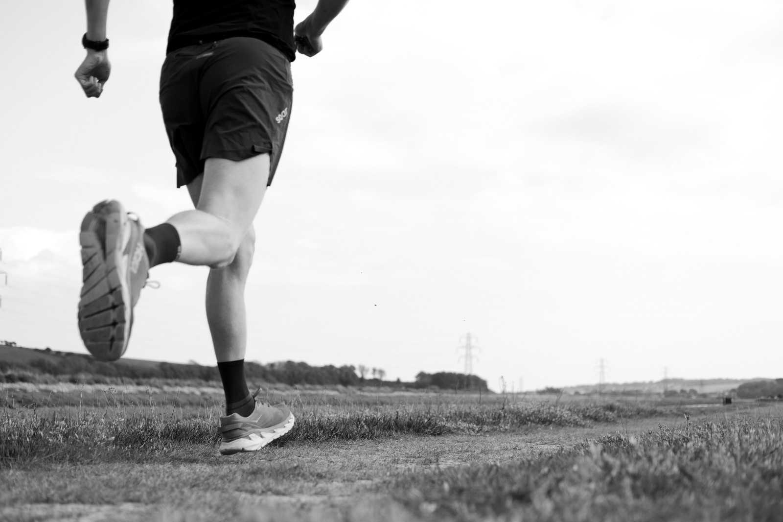 black and white image of male runner focusing on his legs