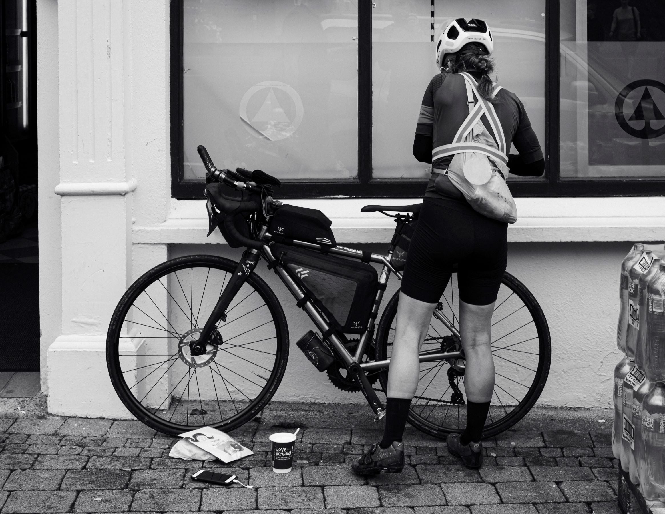 black and white image of female cyclist stopping for refreshments