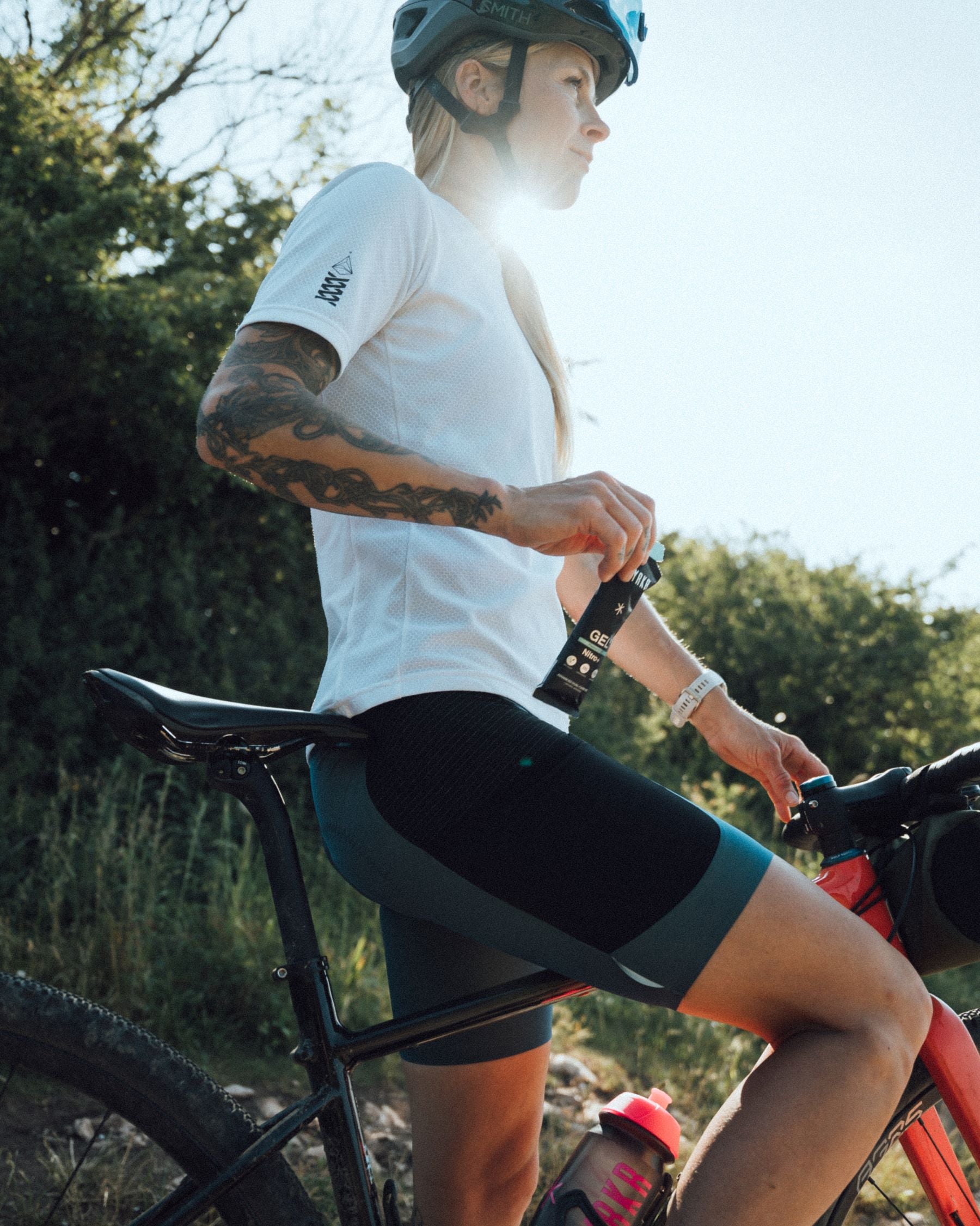 lady athlete on bike using styrkr energy gel