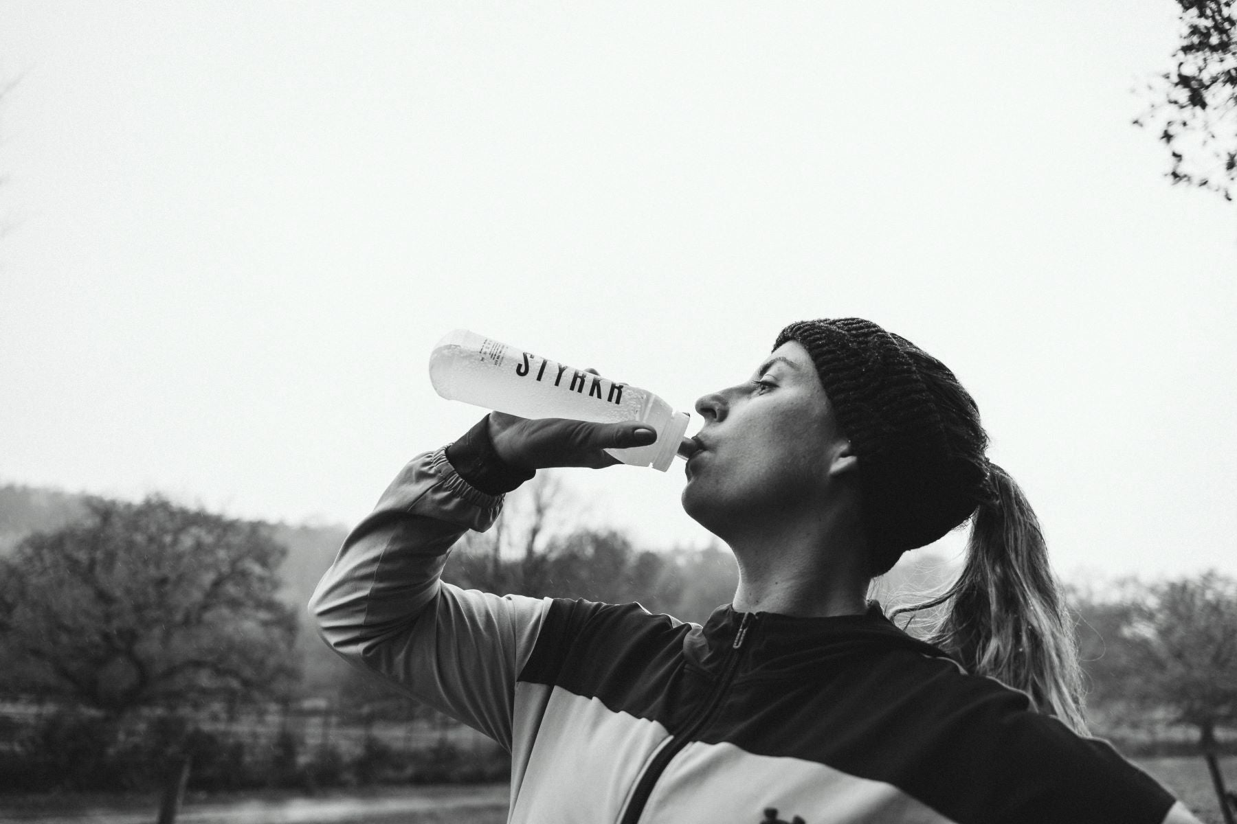 female athlete staying hydrated with a water bottle