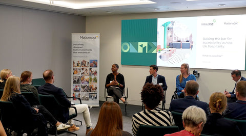 Panel of Pareisse Wilson, Thomas Greenall, and Suzanne Edwards, chaired by Ed Warner in front of a seated audience with a projected display behind