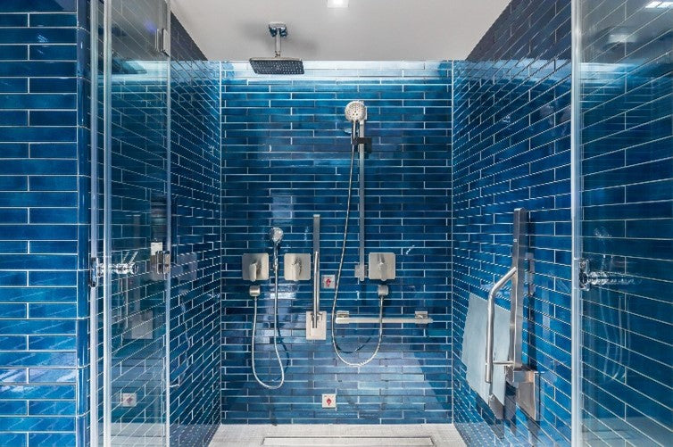 A bright blue metro tiled accessible shower