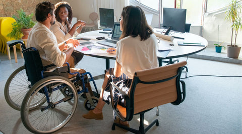 Diverse group of people including a wheelchair user having a meeting in an office space