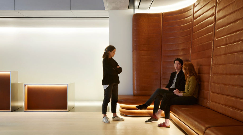 People talking in a comfortable seated area with soft lighting