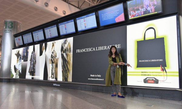 Designer Francesca Liberatore points the Lokithor designed poster on Milan Airport