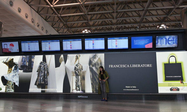 Designer Francesca Liberatore with Lokithor designed poster on Milan Airport