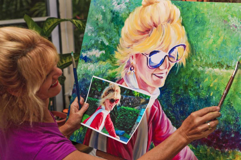 Woman using a reference photo to paint a self-portrait