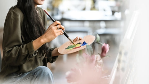 Woman with palette painting portraits in acrylic