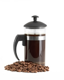 French press surrounded by coffee beans