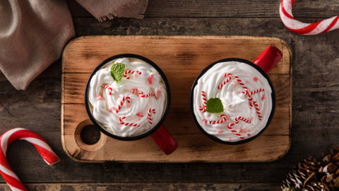 Two candy cane lattes topped with whipped cream and mini candy canes