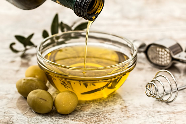 Olive oil, a source of unsaturated fat, poured into a bowl