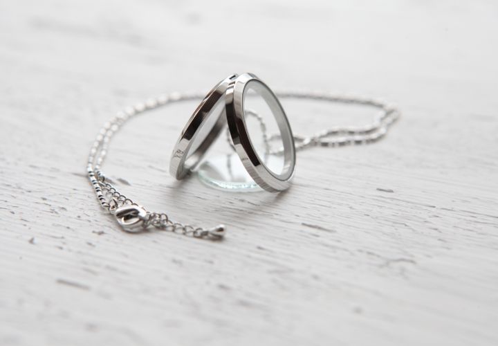 Silver necklace with twin ring pendants on white background.
