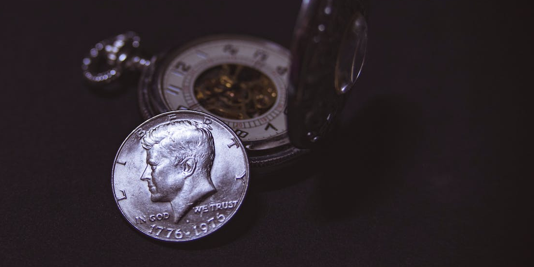 Vintage pocket watch and an old silver coin.