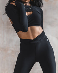 Zoomed view of the black shrug, sports bra, and leggings.