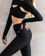 View of the black shrug, black sports bra, and black leggings