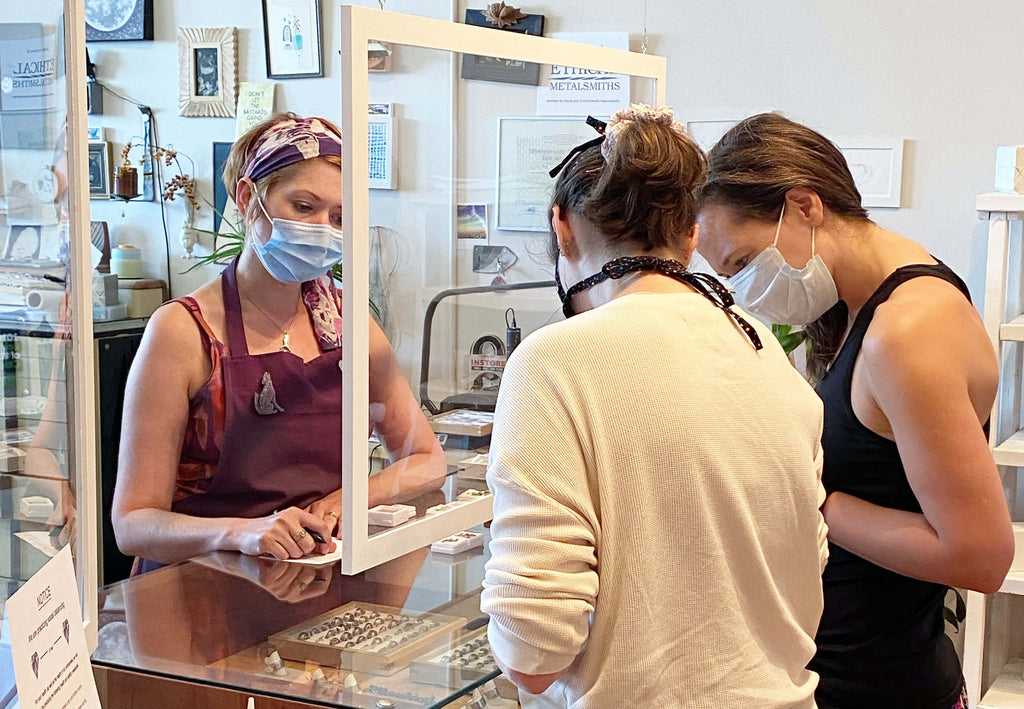 Customers at EC Design Jewelry talking with the owner, Emily Johnson.