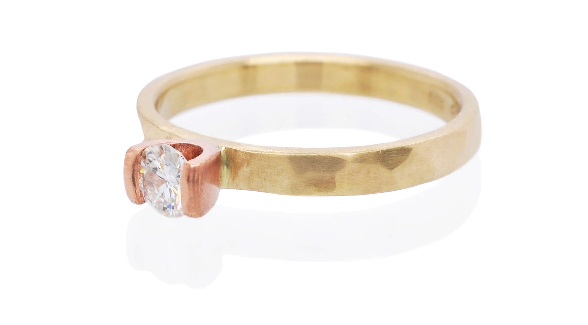 Moissanite engagement ring in rose and yellow gold.