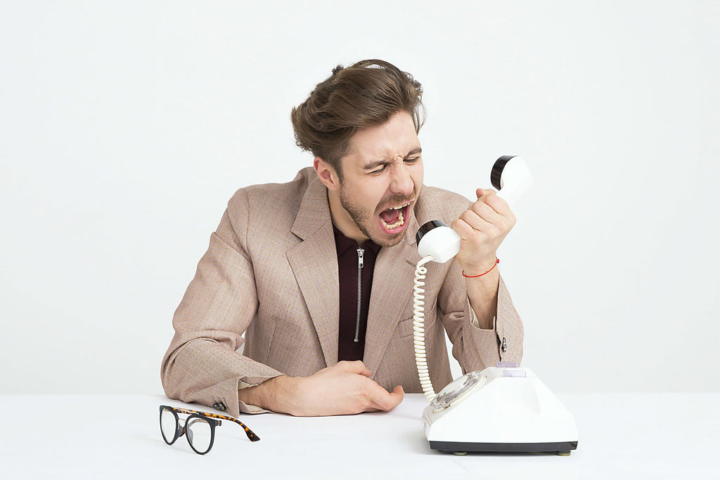 客户对你的业务不满意并不一定是世界末日。使用这些技巧来轻松地处理不愉快的客户体验。图为一名男子对着电话大喊大叫。