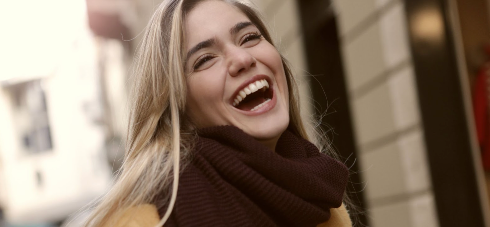Woman laughing in winter wearing a scarf