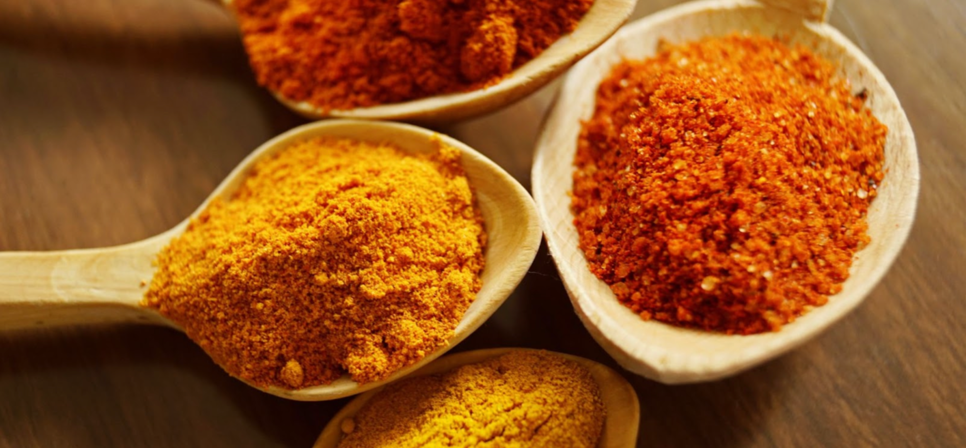 Turmeric spices on wooden spoons