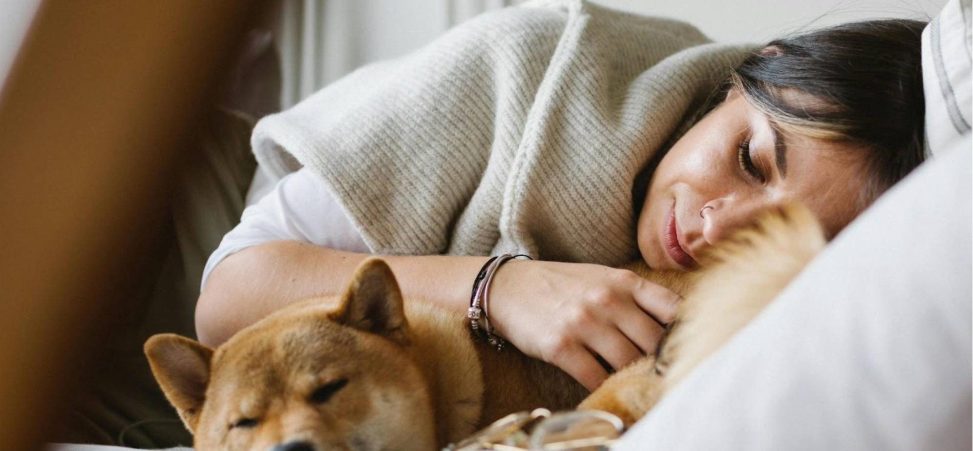 Woman sleeping and dog sleeping next to her