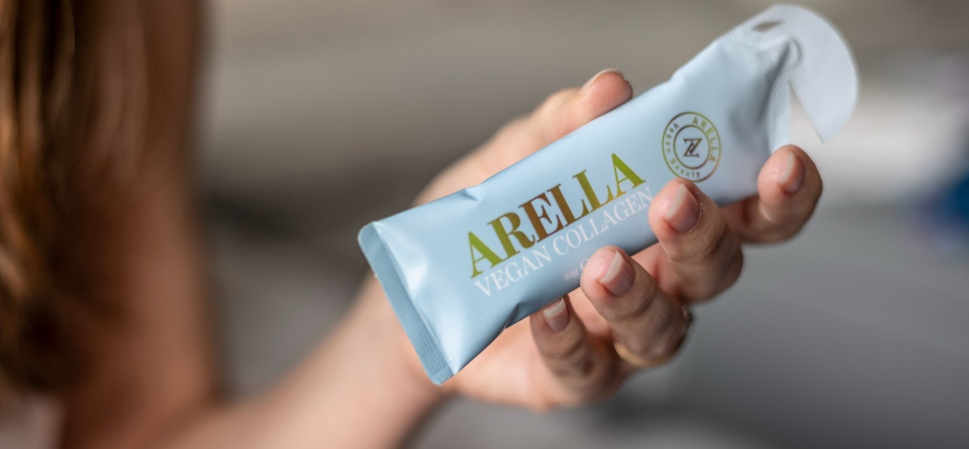 Woman holding Arella Beauty’s Liquid Vegan Collagen containing vitamin C
