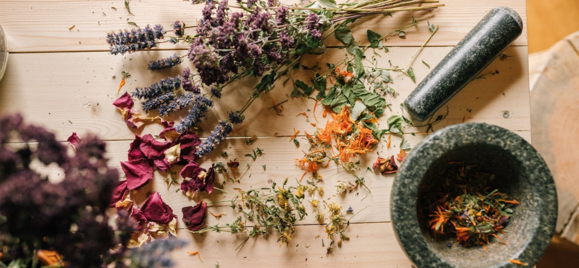 Dried herbs and flowers with a pestle and mortar