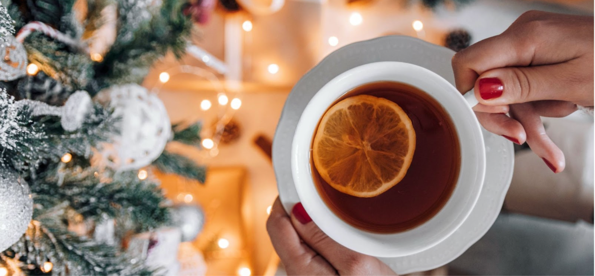 Woman holding a hot Christmas drink with an orange slice