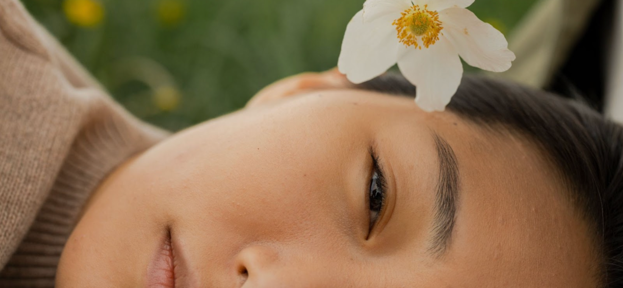 Asian woman lying down with a white flower in her hair