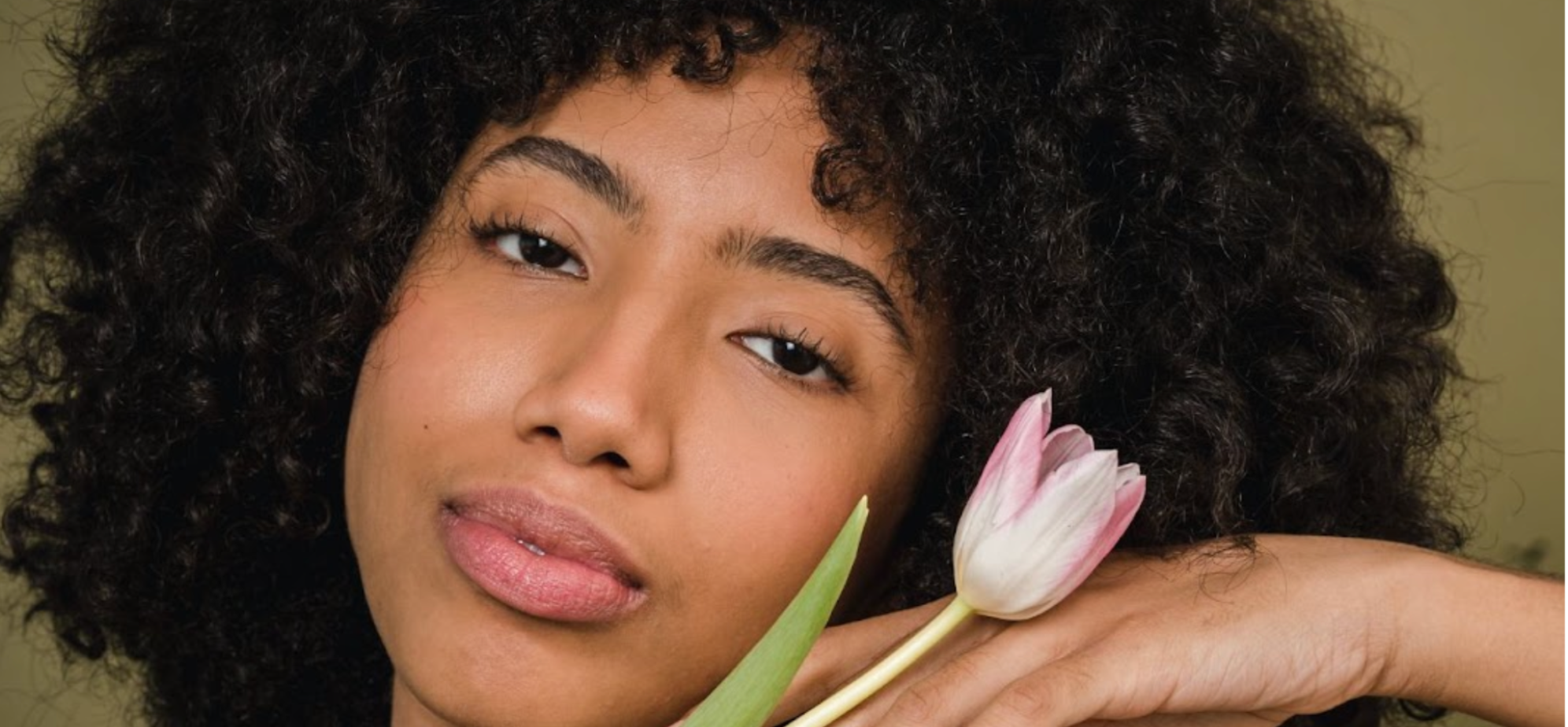 Beautiful black woman with clear skin holding a tulip