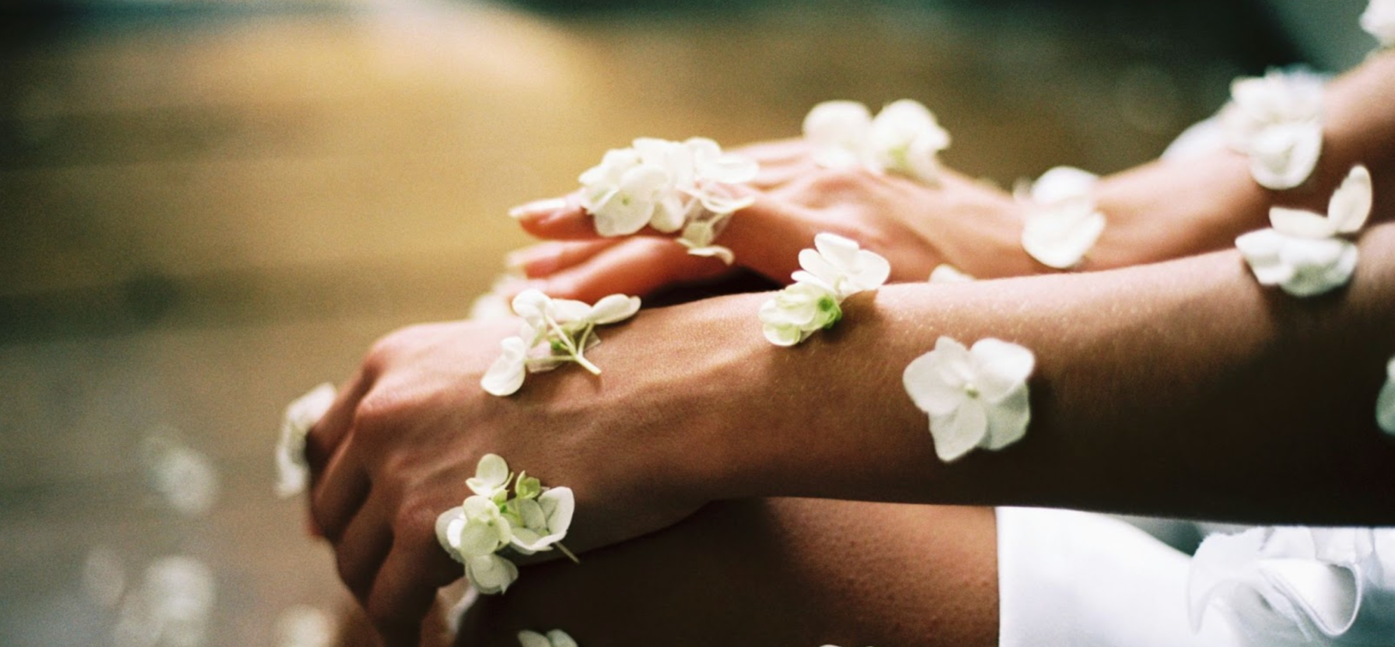 Person sitting cross-legged with white flowers on their skin