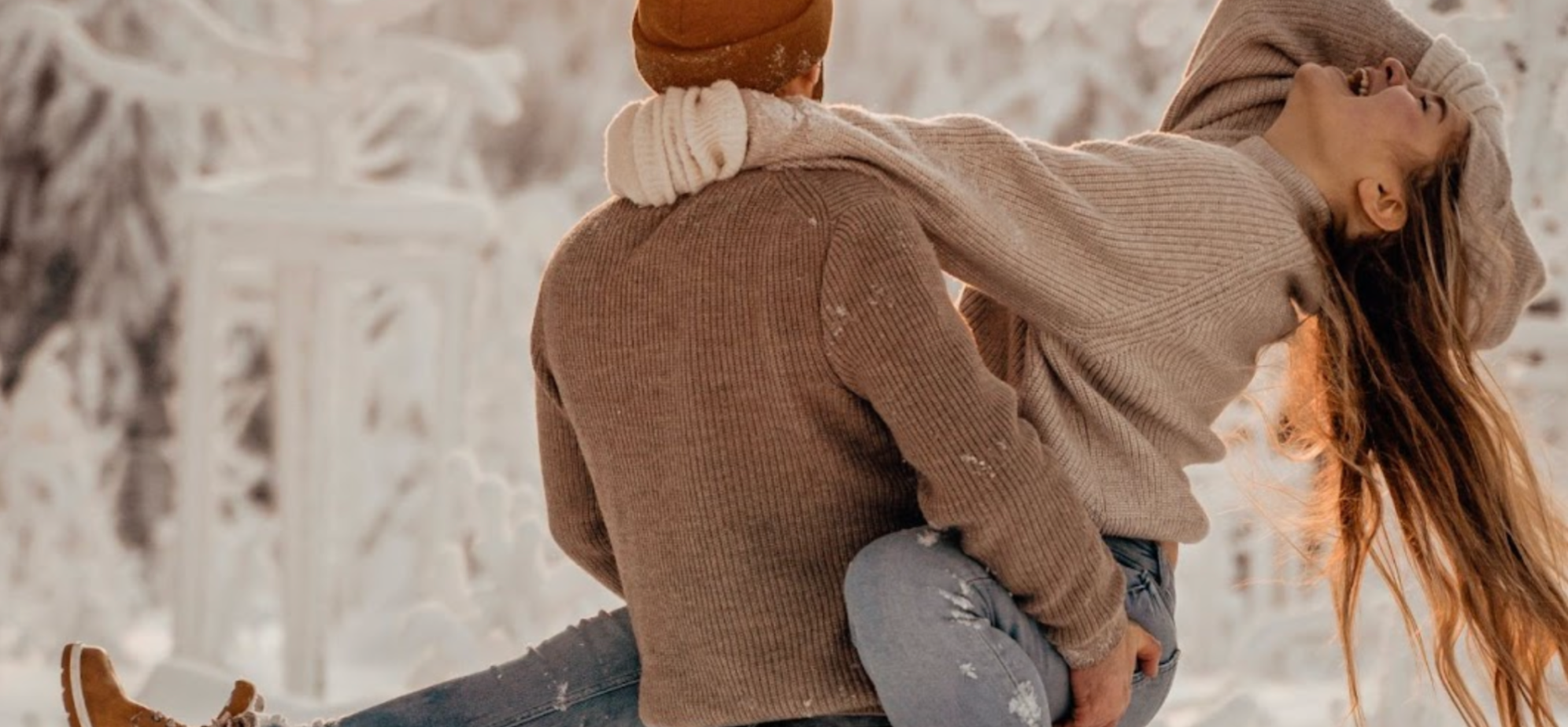 Woman and man laughing in the winter snow