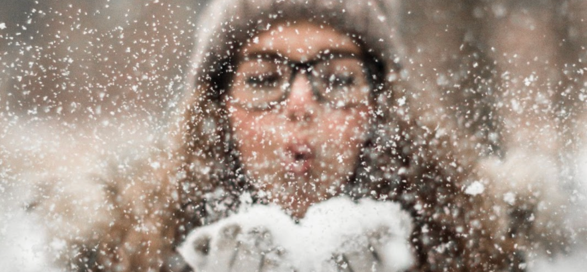 Woman blowing snow in winter