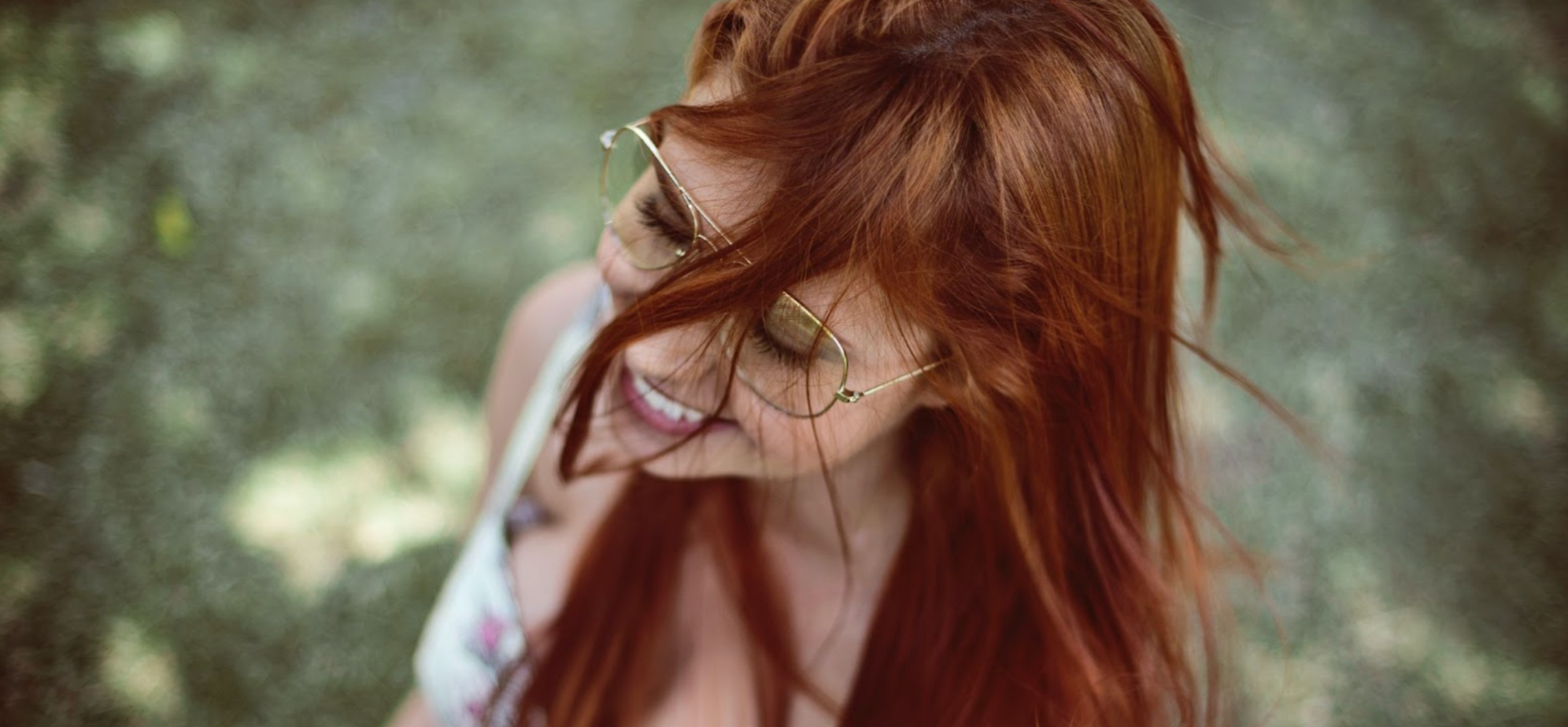 Laughing woman with red hair and glasses