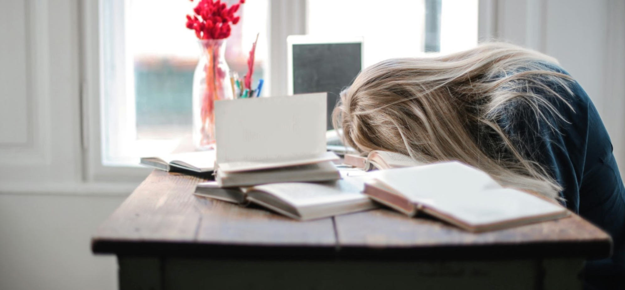 Tired woman sleeping with her head on her desk