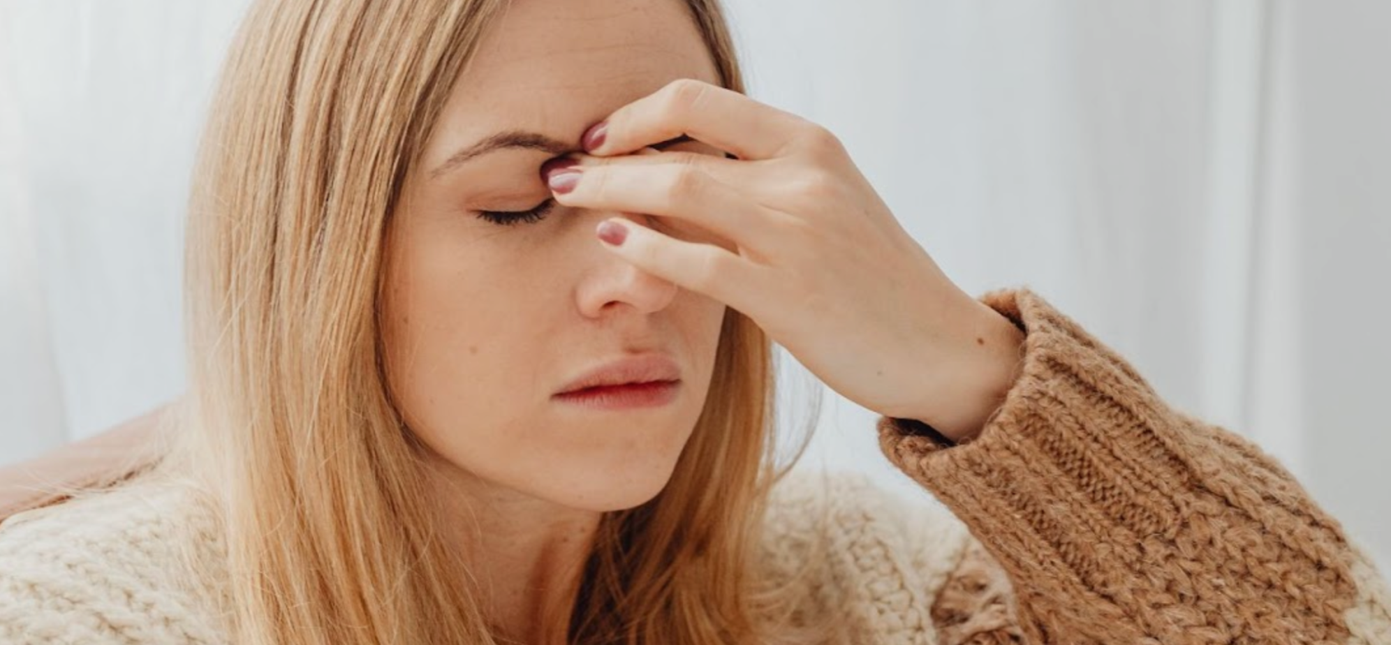 Woman feeling ill with a headache from not enough vitamin C