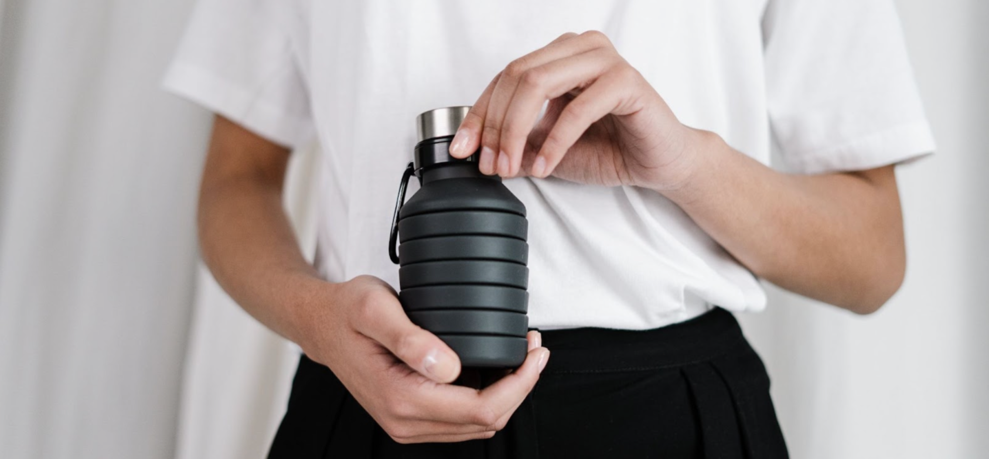 Person holding a reusable, metal water bottle