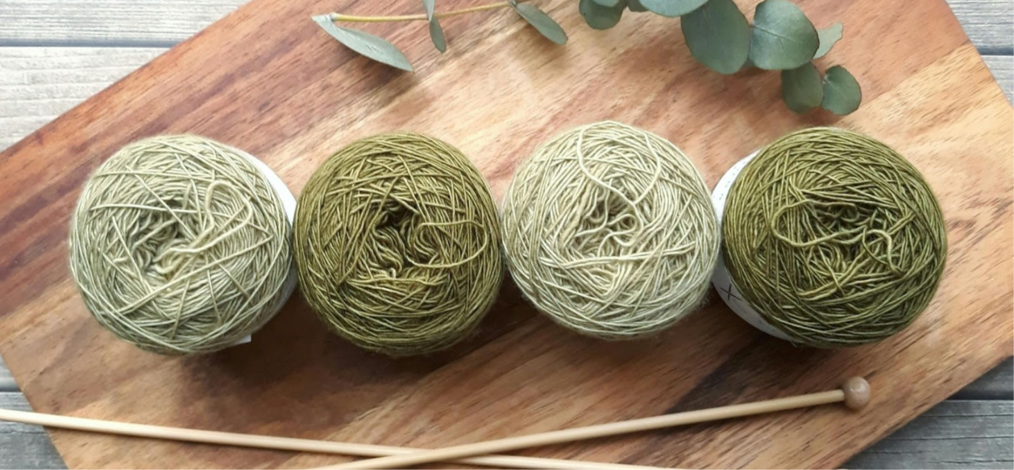 Balls of green yarn and knitting needles