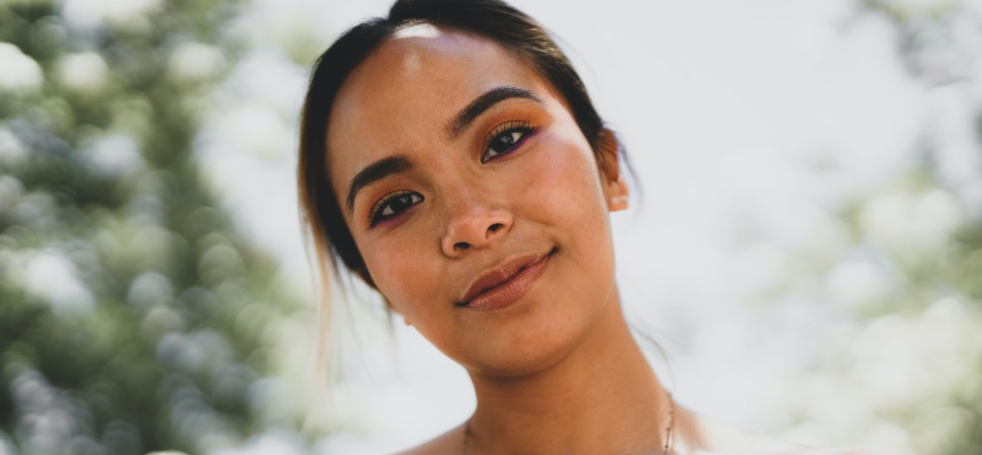 Woman smiling slightly with her head tilted.