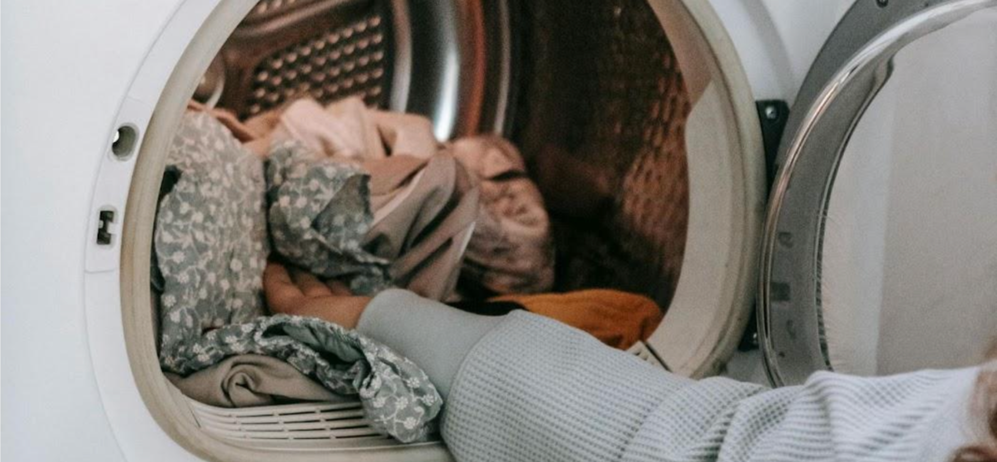 Woman putting laundry into a washing machine